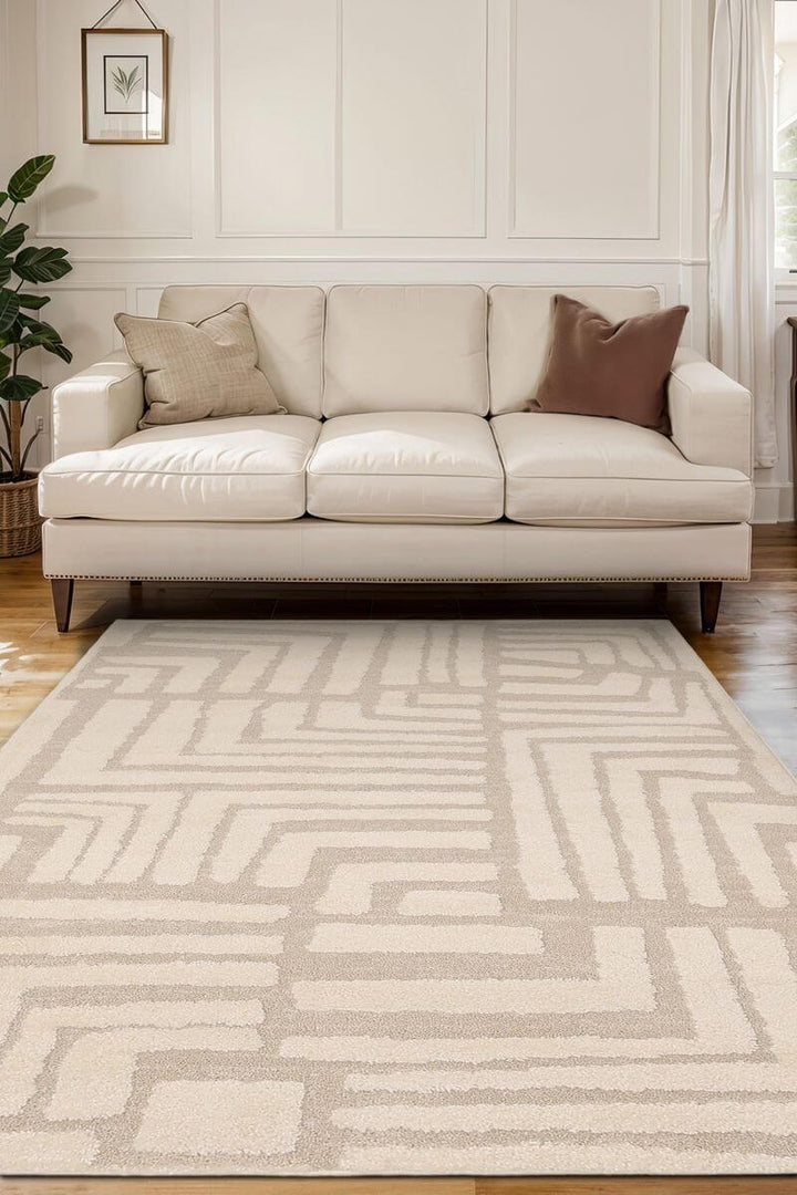Ava Pave Wave Illusion Rug in cream tones, featuring an abstract design, placed in a modern living room with a beige sofa.