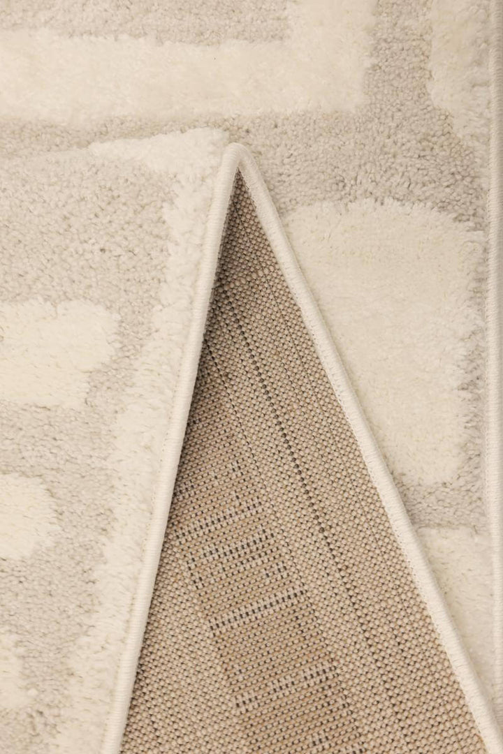 Close-up of the Ava Pave Wave Illusion Rug showcasing its soft cream texture and high-low pile design.