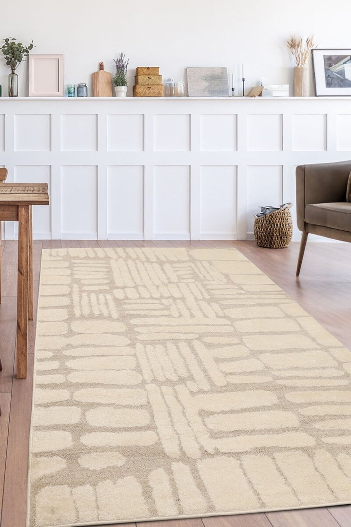 Ava Pave Wave Illusion Rug in cream, showcasing abstract design on wooden floor in stylish modern living room.