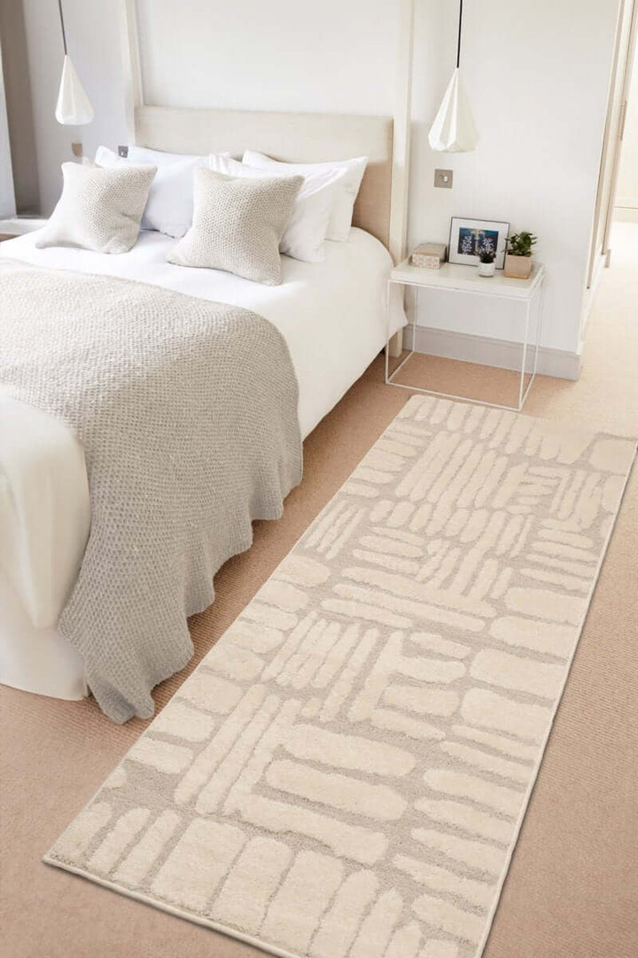 Ava Pave Wave Illusion Rug in cream, featuring abstract design on a soft carpet in a modern bedroom setting.