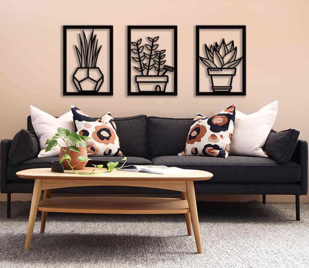 Modern living room featuring black plant-themed wall art, a cozy sofa with patterned pillows, and a stylish coffee table.