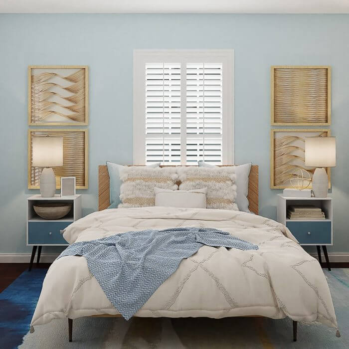 Modern cozy bedroom with a blue theme, featuring a bed, lamps, and decorative wall art.