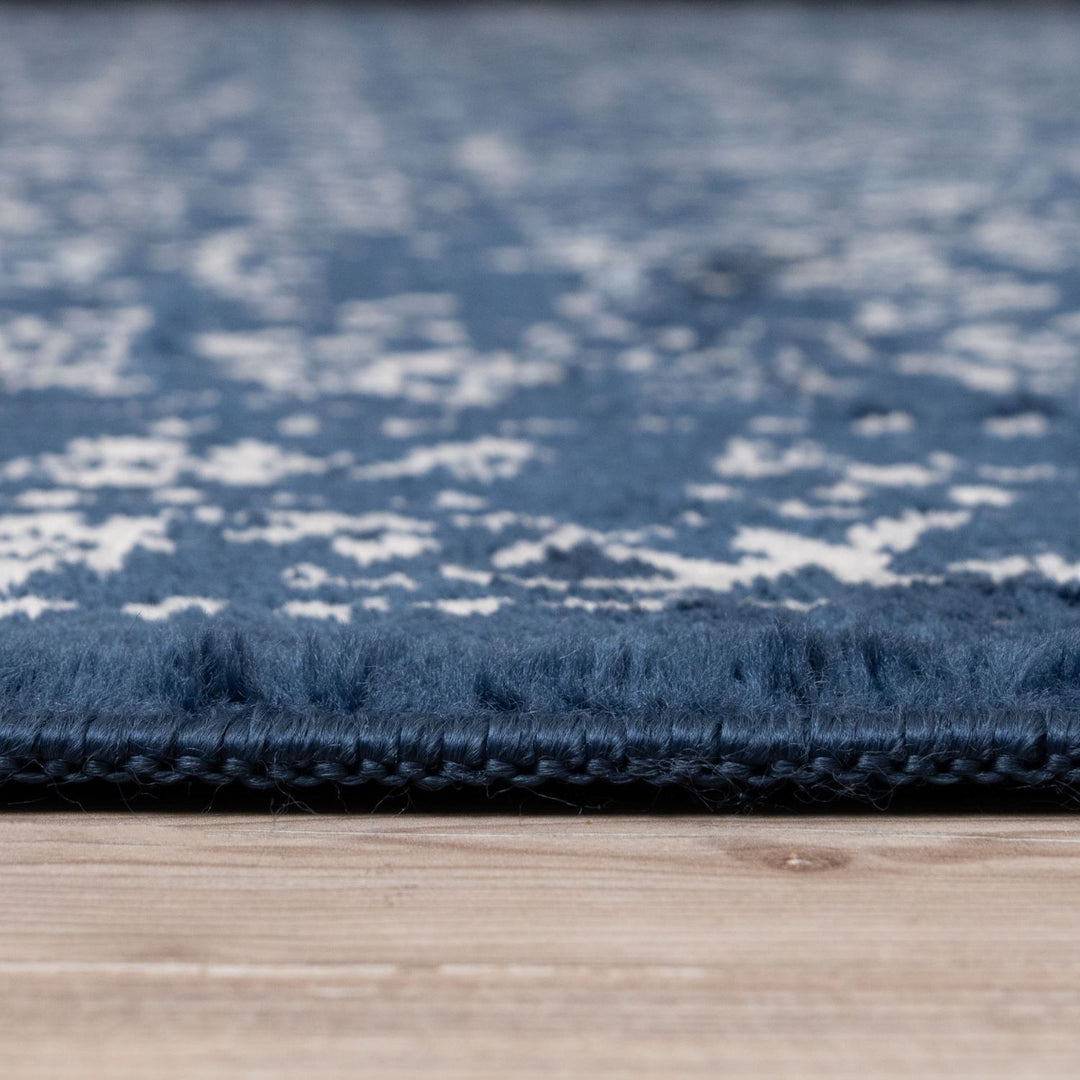 Close-up of a blue textured rug on a wooden floor