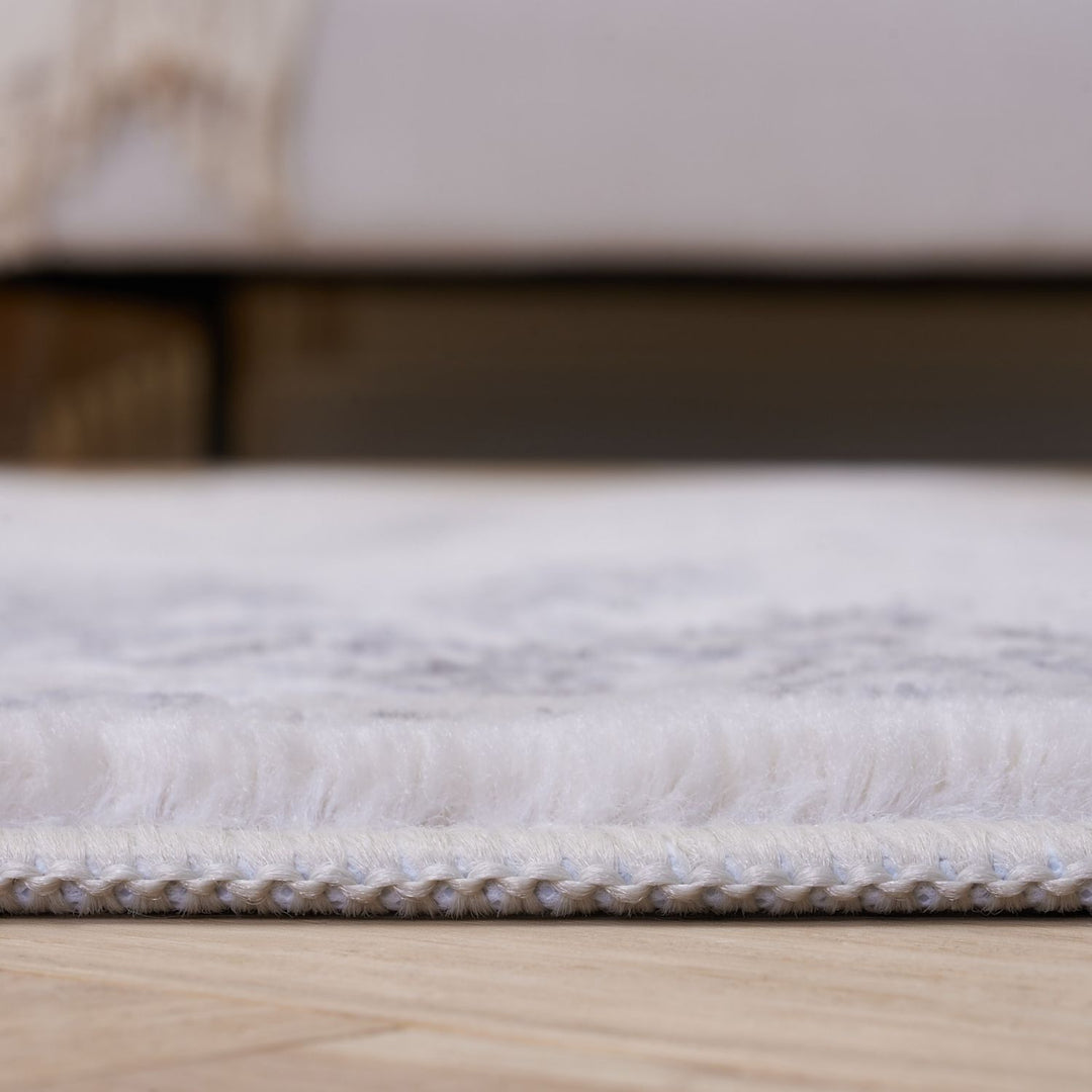 Close-up of a textured white rug on a wooden floor