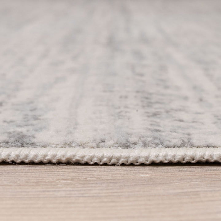cream and grey rug features an abstract pattern