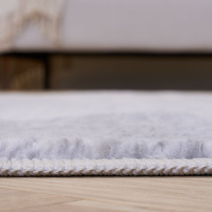 Close-up of a textured white rug on a wooden floor