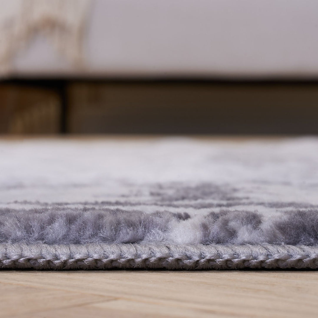 Gray textured rug on a wooden floor with a blurred background