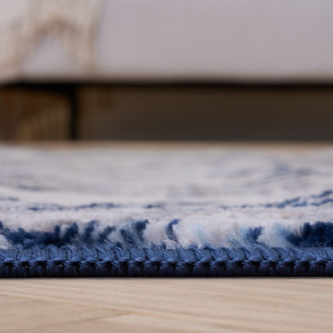 Close-up of a blue and white patterned rug on a wooden floor.