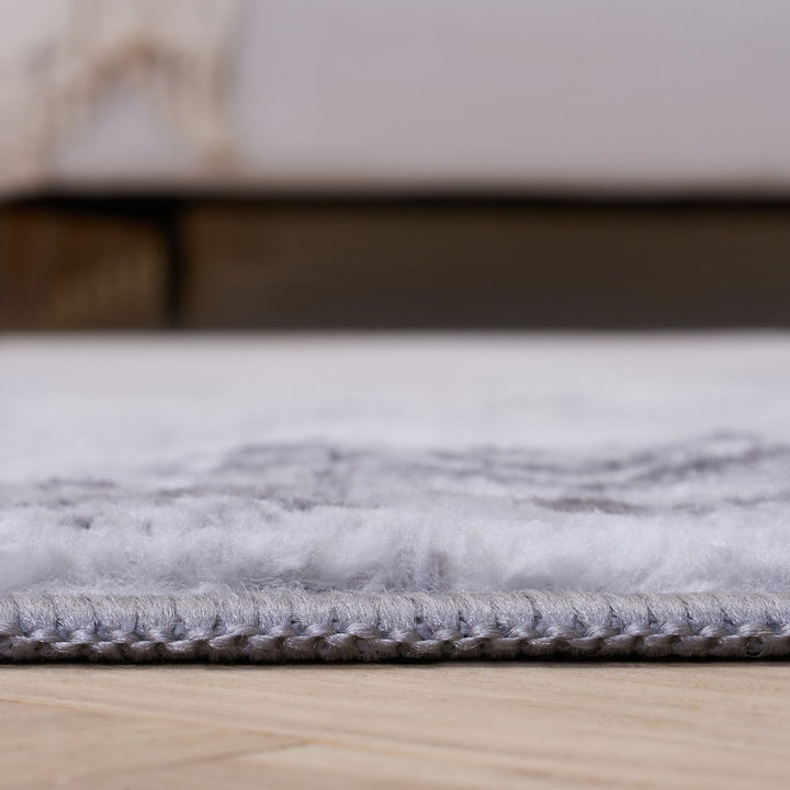 Gray rug on a wooden floor with a blurred background