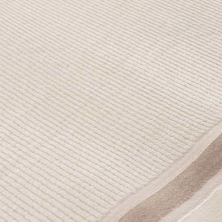 Close-up of a textured beige rug with a subtle pattern