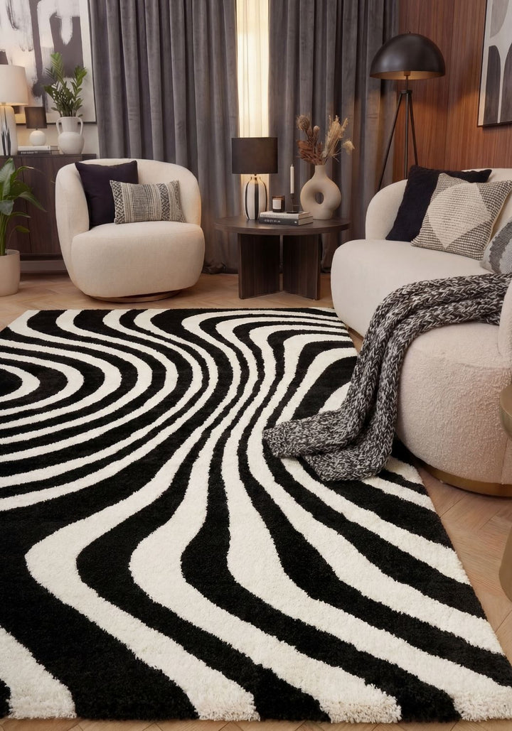 Living room with a black and white patterned rug, white chairs, and decorative elements.