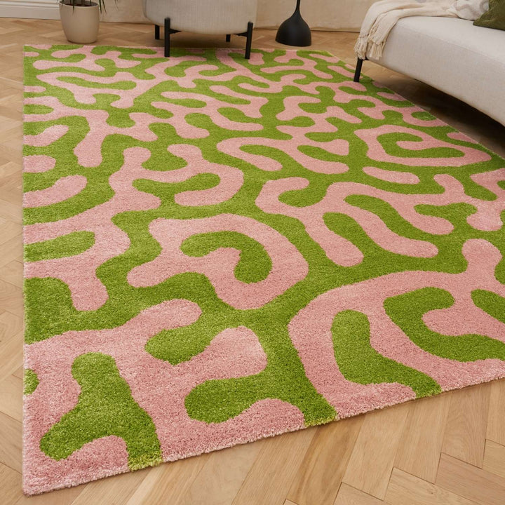 Pink and green patterned rug on a wooden floor