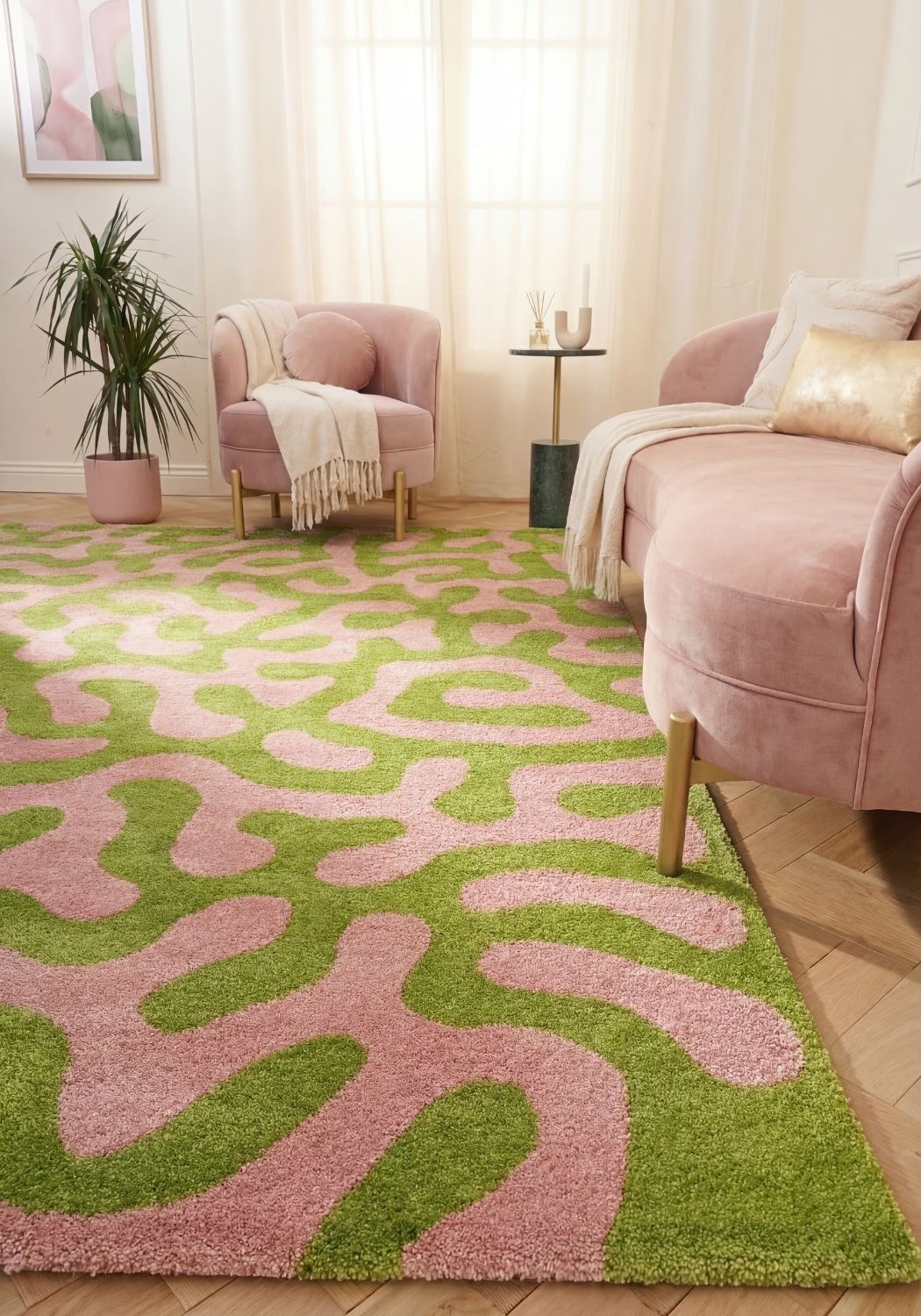 Living room with a pink and green patterned rug, pink sofa, and armchair.