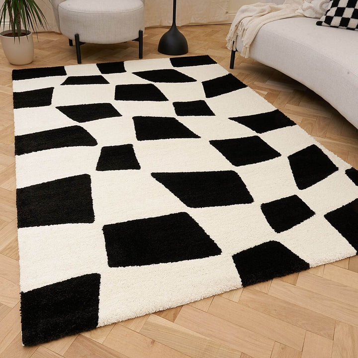 Black and white checkered rug on a wooden floor in a living room setting.