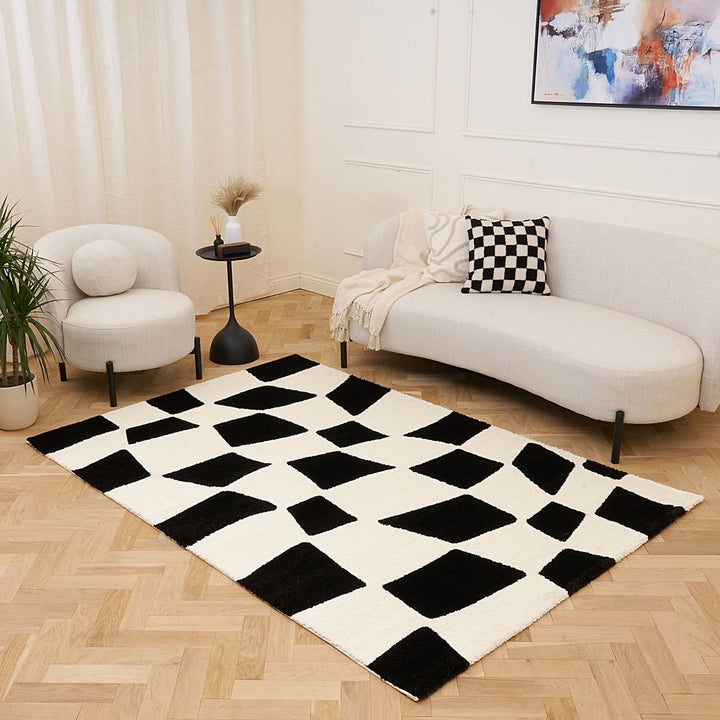 Black and white checkered rug in a living room with a sofa and armchair.