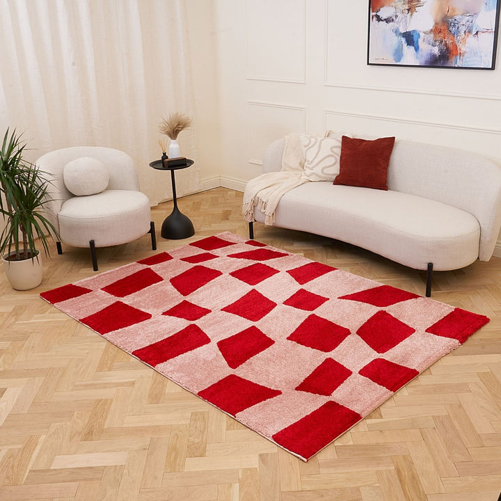 Living room with a red and beige checkered rug, white sofa, and armchair.