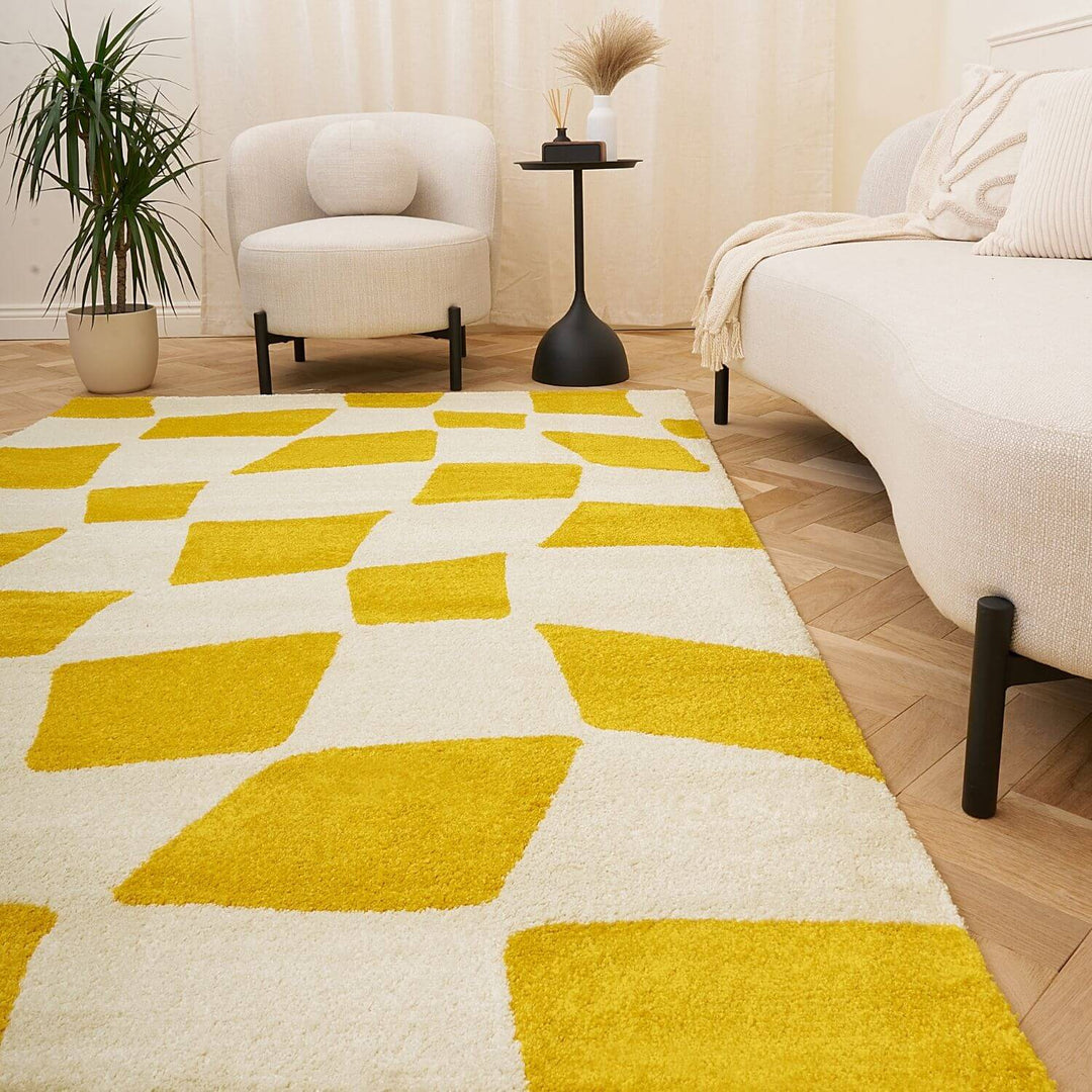 Yellow and white geometric patterned rug in a living room setting with a chair and side table.