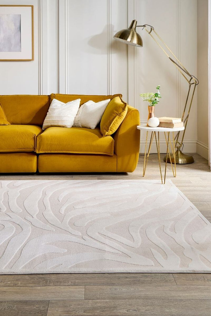 Modern abstract geometric rug in cream shades accenting a cozy living room with a yellow sofa.