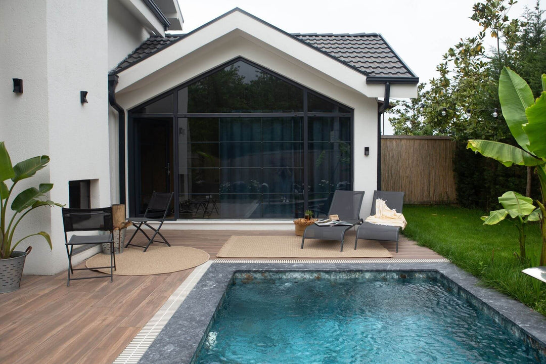 modern patio with pool and lounge chairs in a backyard setting