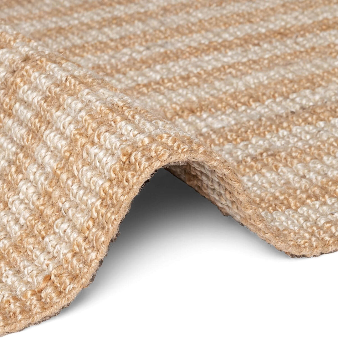 Close-up of a textured beige carpet corner on a white background