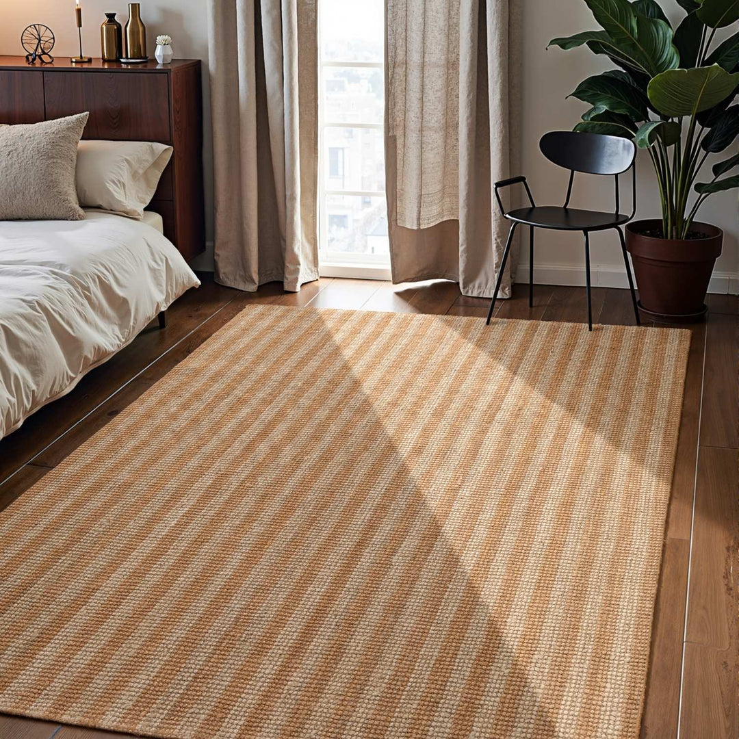 Striped rug in a bedroom with a bed, chair, and plant.