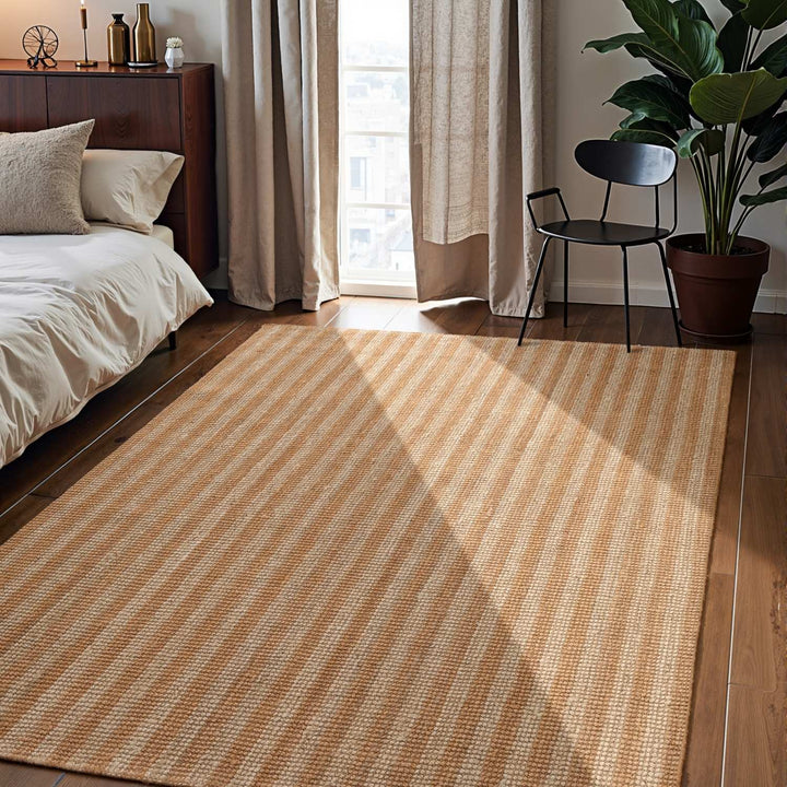Striped rug in a bedroom with a bed, chair, and plant.