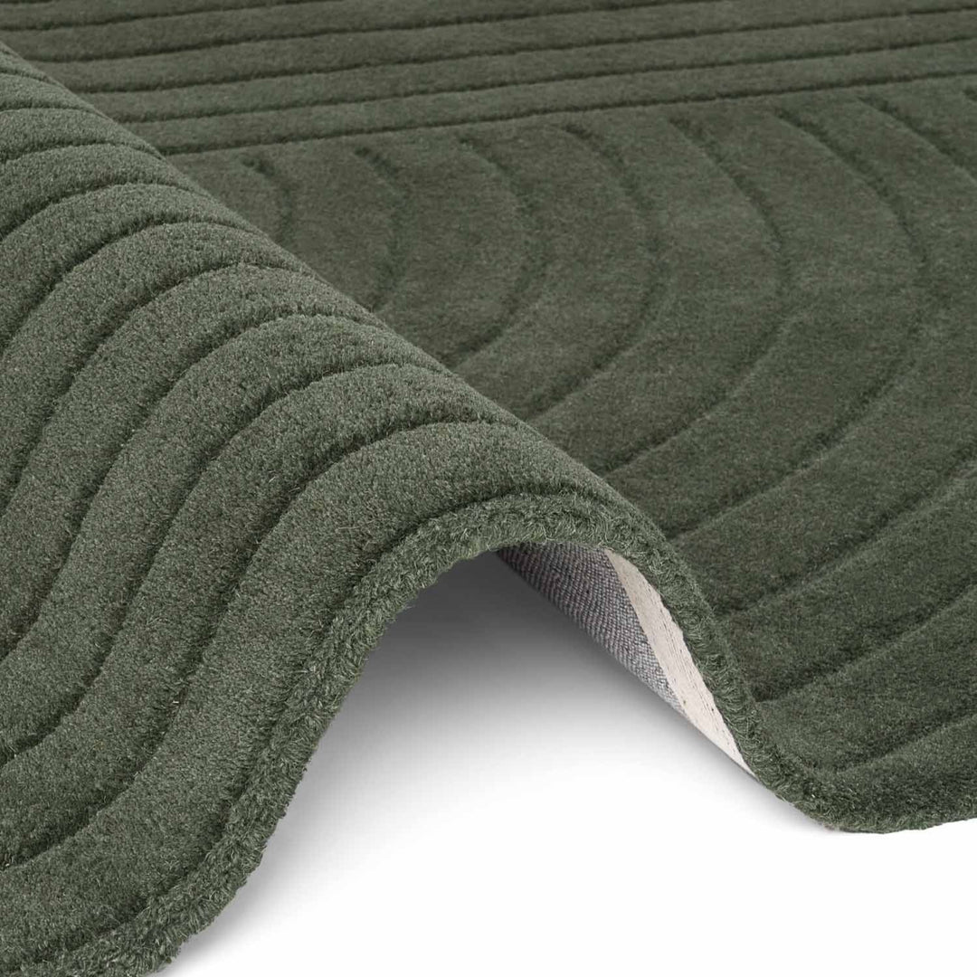 Close-up of green textured rug with patterned surface