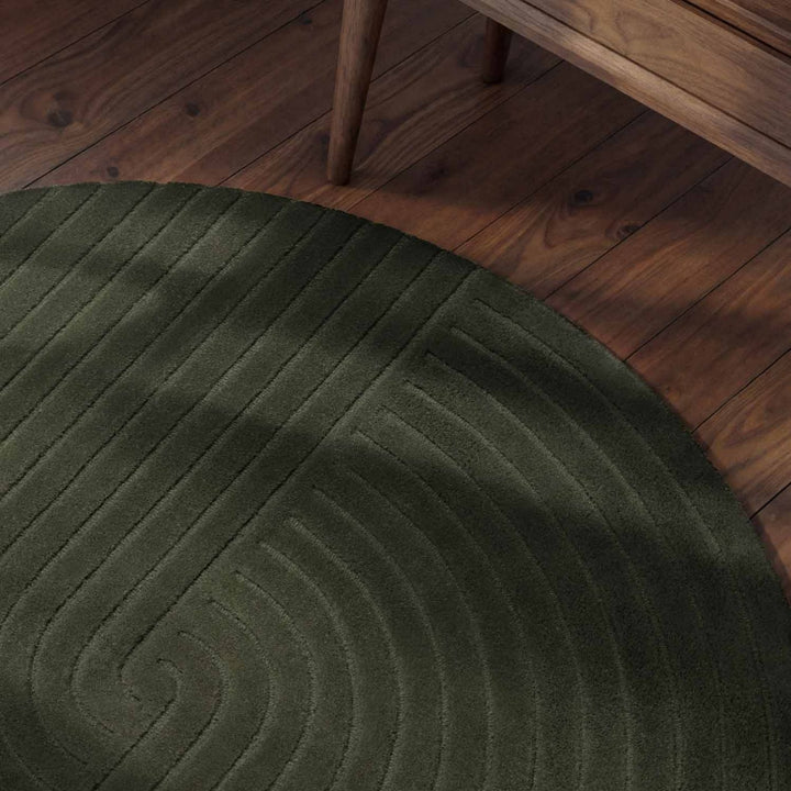 Green round rug on a wooden floor