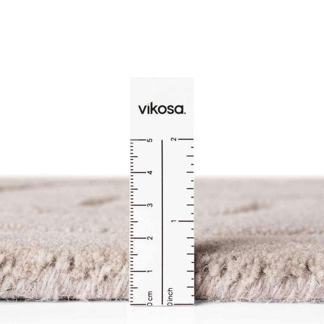 Rug with a ruler for scale on a white background, featuring the brand 'vikosa'.