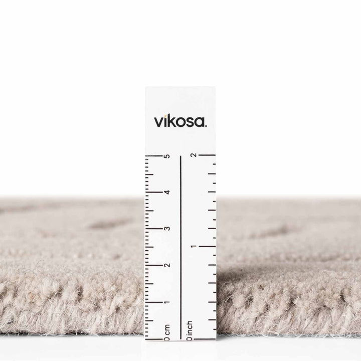 Rug with a ruler for scale on a white background, featuring the brand 'vikosa'.
