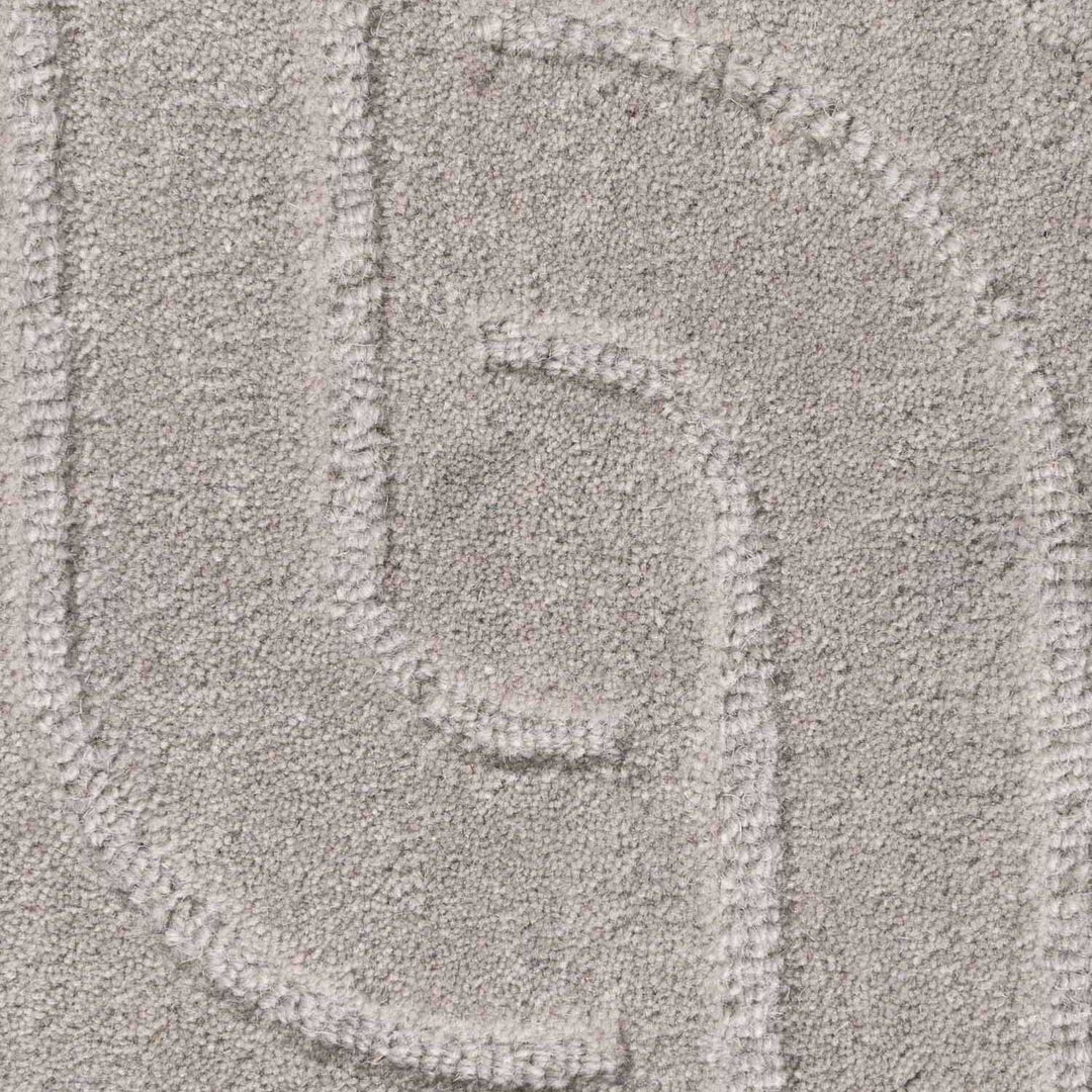 Close-up of a textured gray surface with a pattern resembling a stylized letter 'G'.