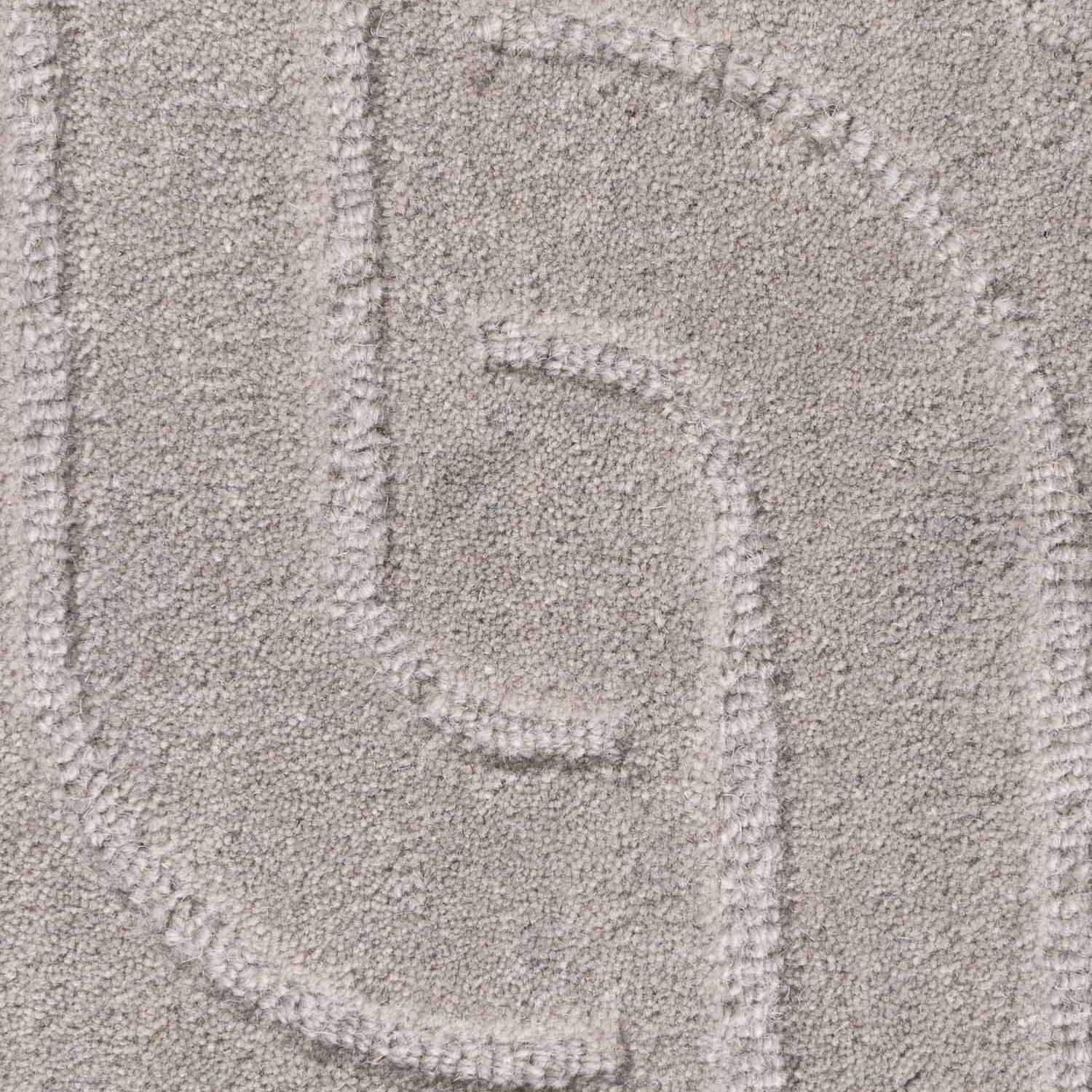 Close-up of a textured gray surface with a pattern resembling a stylized letter 'G'.