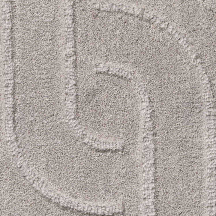 Close-up of a textured gray surface with a pattern resembling a stylized letter 'G'.