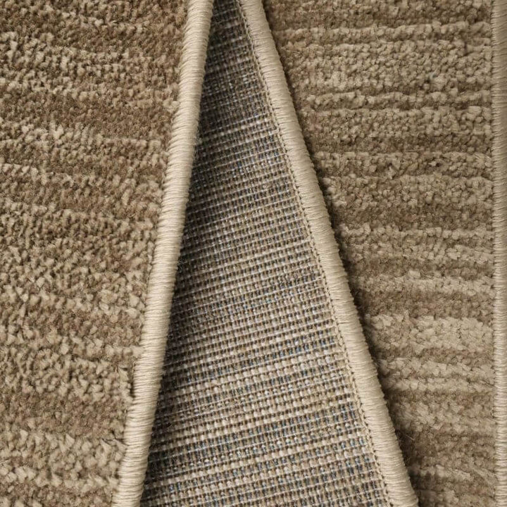 Close-up of the Arlo Textured Rug showcasing its soft pile and durable backing in a neutral brown tone.
