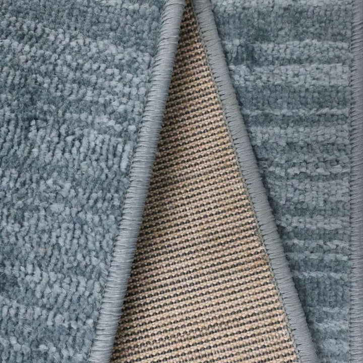 Close-up of Arlo Textured Rug showcasing soft blue tone texture and durable backing.