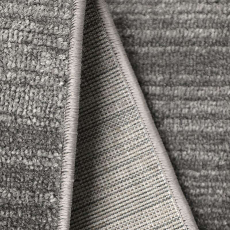 Close-up of Arlo Textured Rug showing soft grey tone, durable polyester fabric and refined edge detailing.