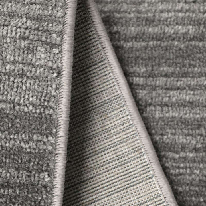Close-up of Arlo Textured Rug showing soft grey tone, durable polyester fabric and refined edge detailing.