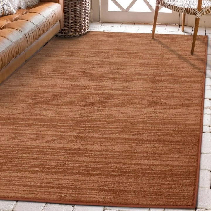 Arlo Textured Rug in warm brown tone with soft stripes, enhancing a cozy living room space.