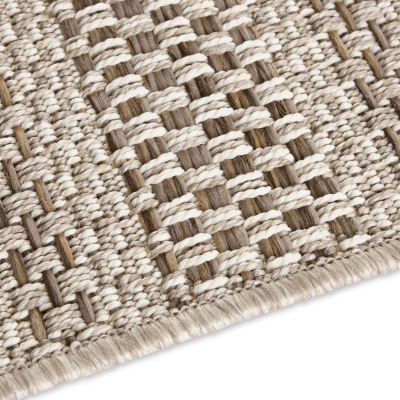 Close-up of a woven textured rug with a geometric pattern on a white background