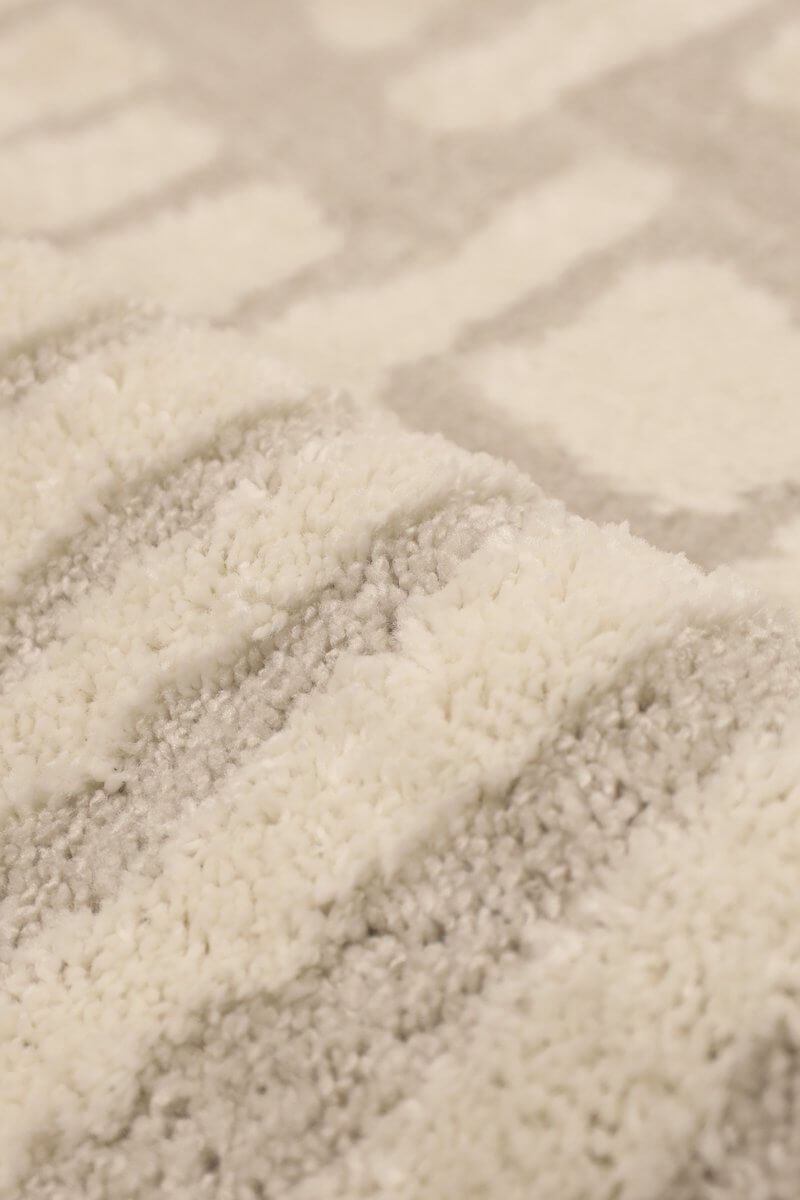 Close-up of the Ava Pave Wave Illusion Rug showcasing its cream abstract design and plush high-low pile texture.