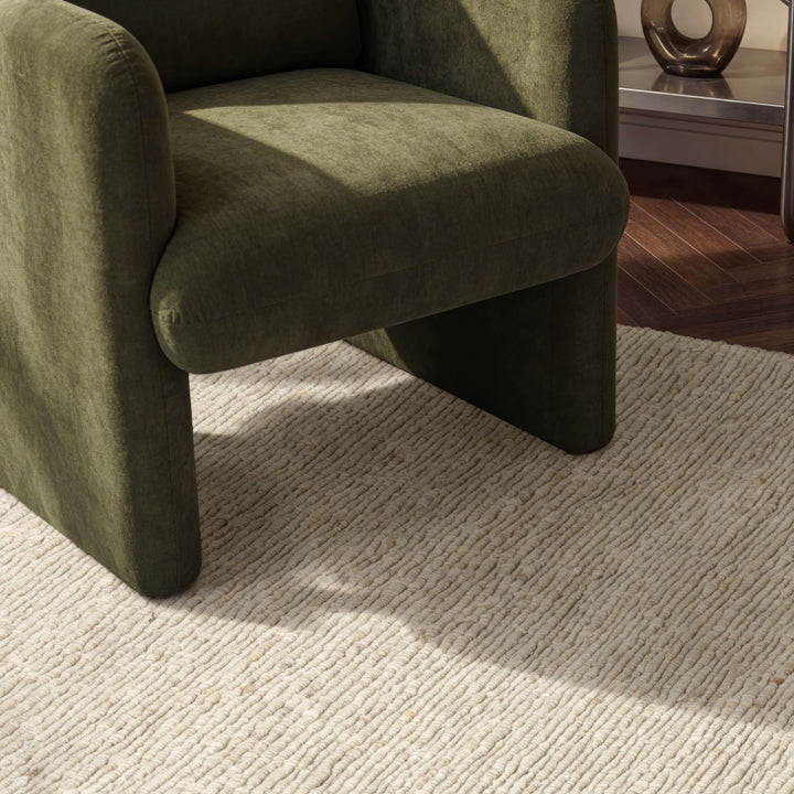 Green armchair on a textured beige carpet