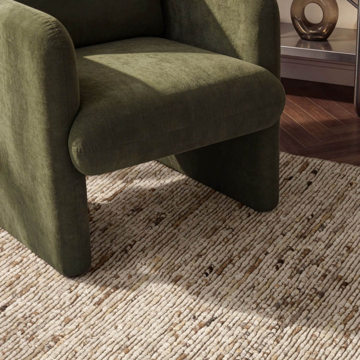 Green armchair on a textured rug with a blurred background
