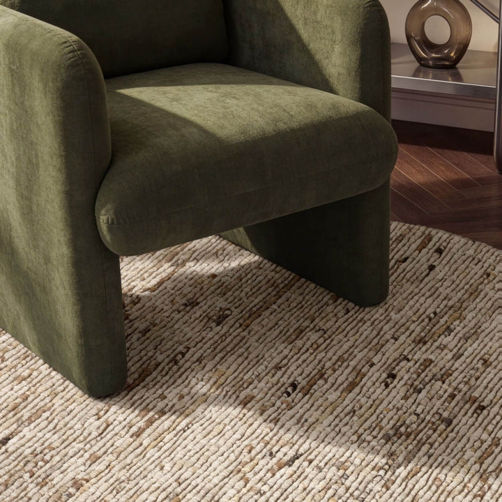 Green armchair on a textured rug with a blurred background