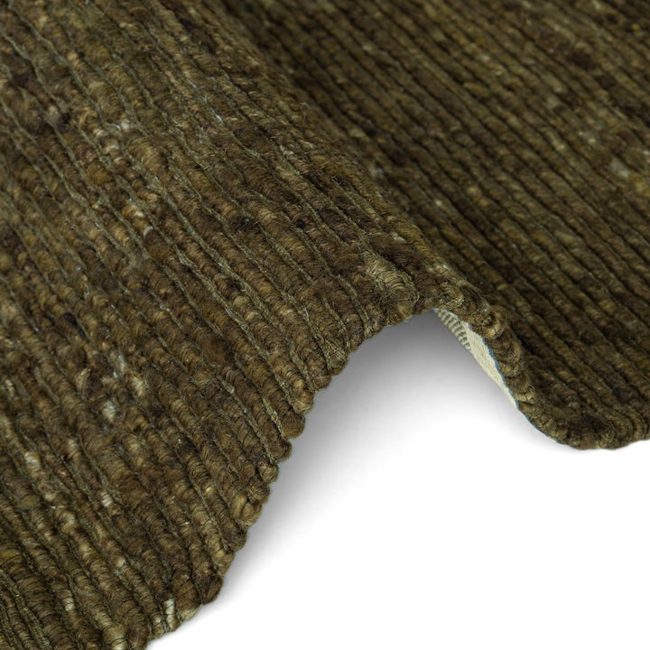 Close-up of a textured brown carpet corner on a white background