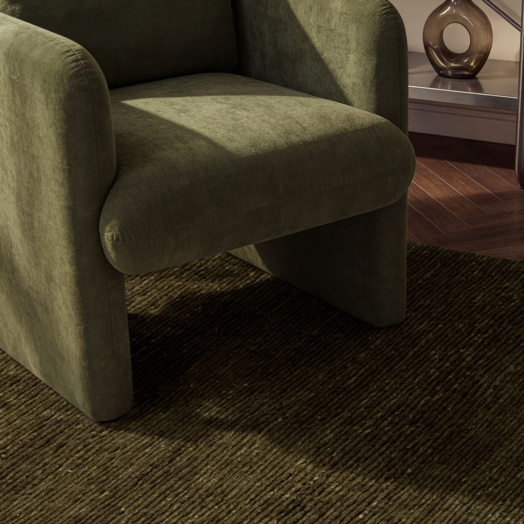 Green armchair on a dark textured carpet