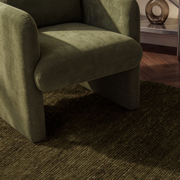 Green armchair on a textured brown carpet