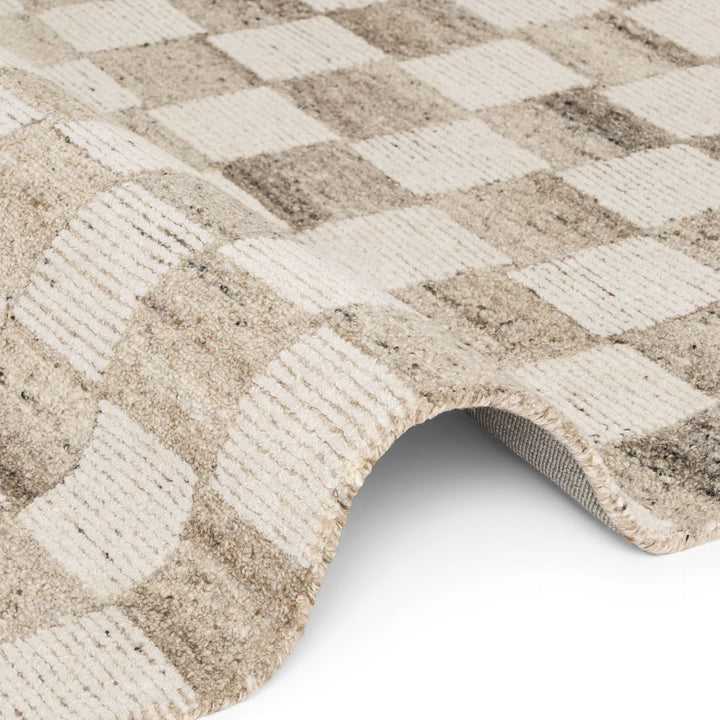 Close-up of a textured beige and white checkered rug