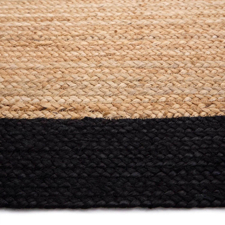 Close-up of a woven rug with a natural top layer and black bottom layer.