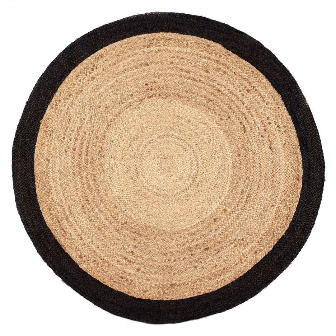 Round jute rug with black border on a white background