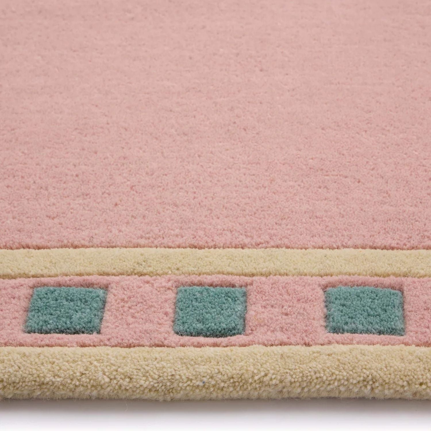 Close-up of a pink rug with geometric patterns on a white background